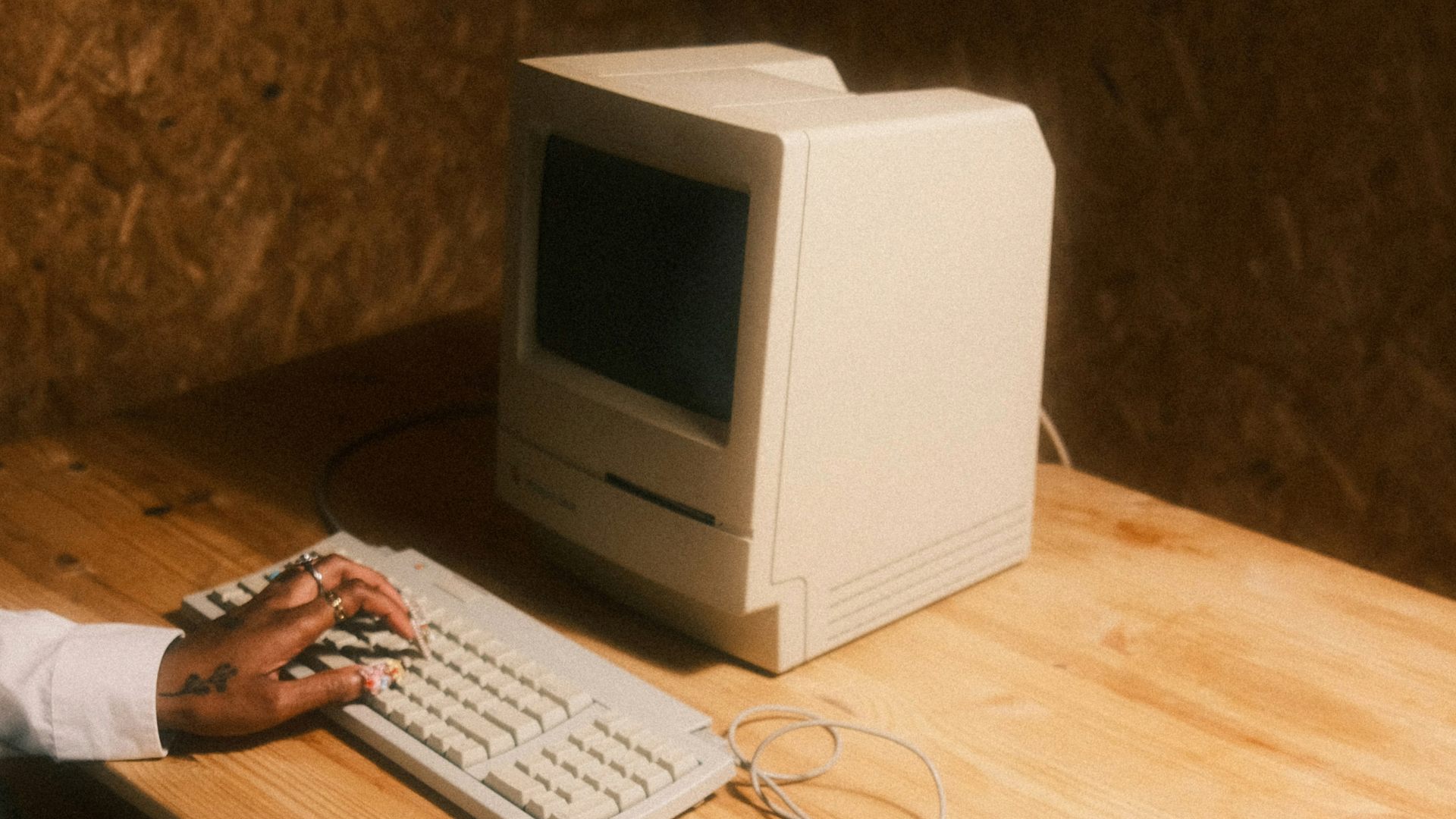 Hand using a 1985 Apple Macintosh